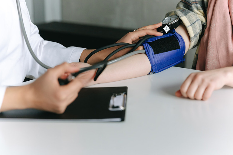 Una profesional sanitaria comprueba si un paciente presenta hipertensión